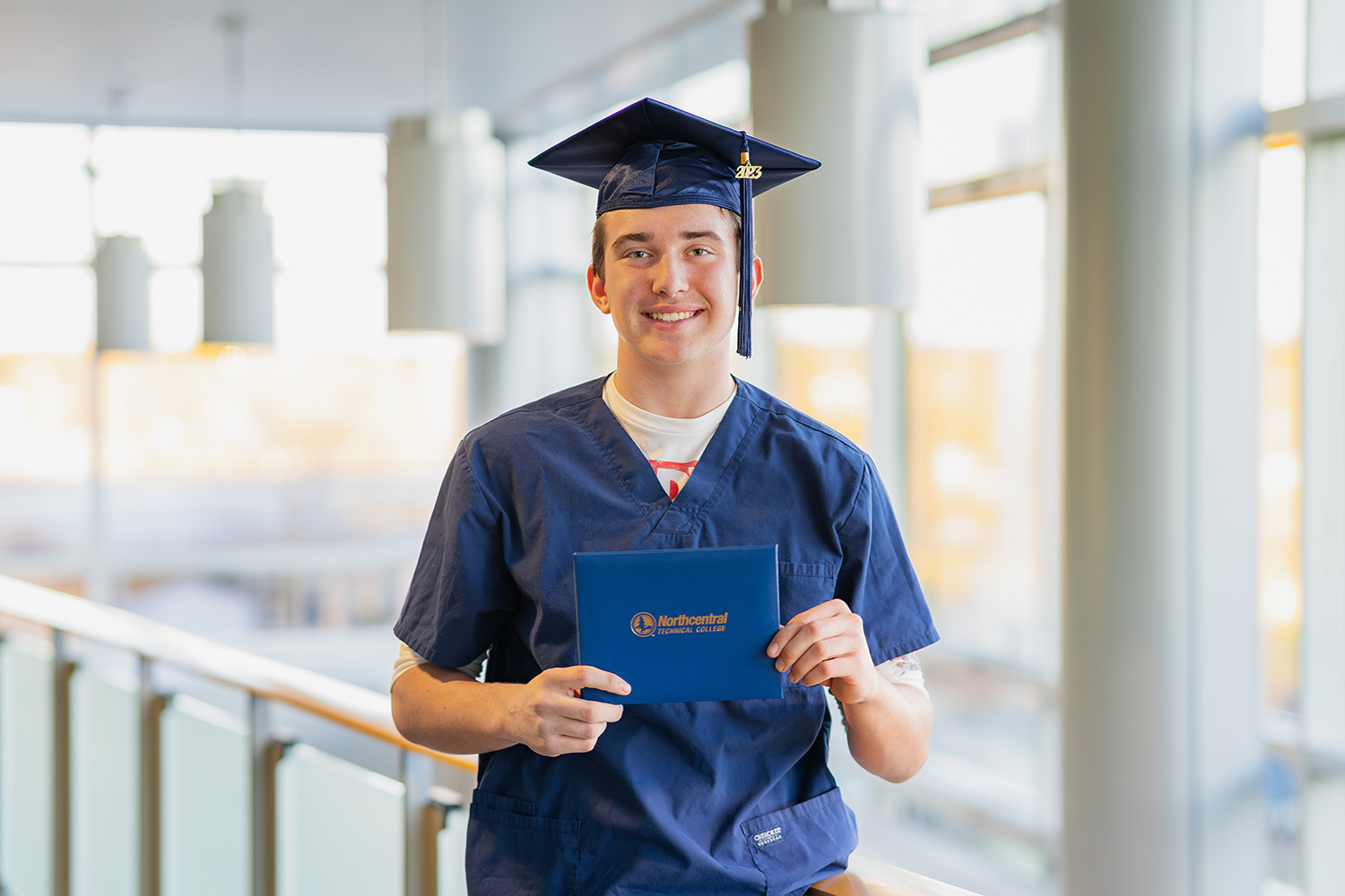 Dan'l posing while wearing an NTC graduation cap and holding his diploma.