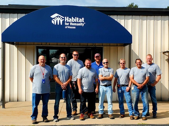 Staff of NTC’s Facilities team stand together after donating their time to help Habitat for Humanity of Wausau.