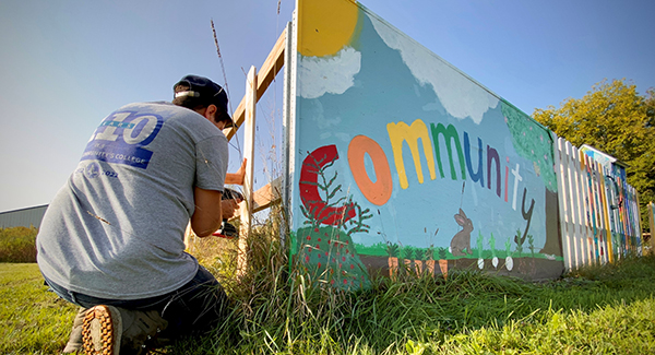 Video Production Faculty, Jordan Innes, building a fence at the Birnamwood Community Garden.