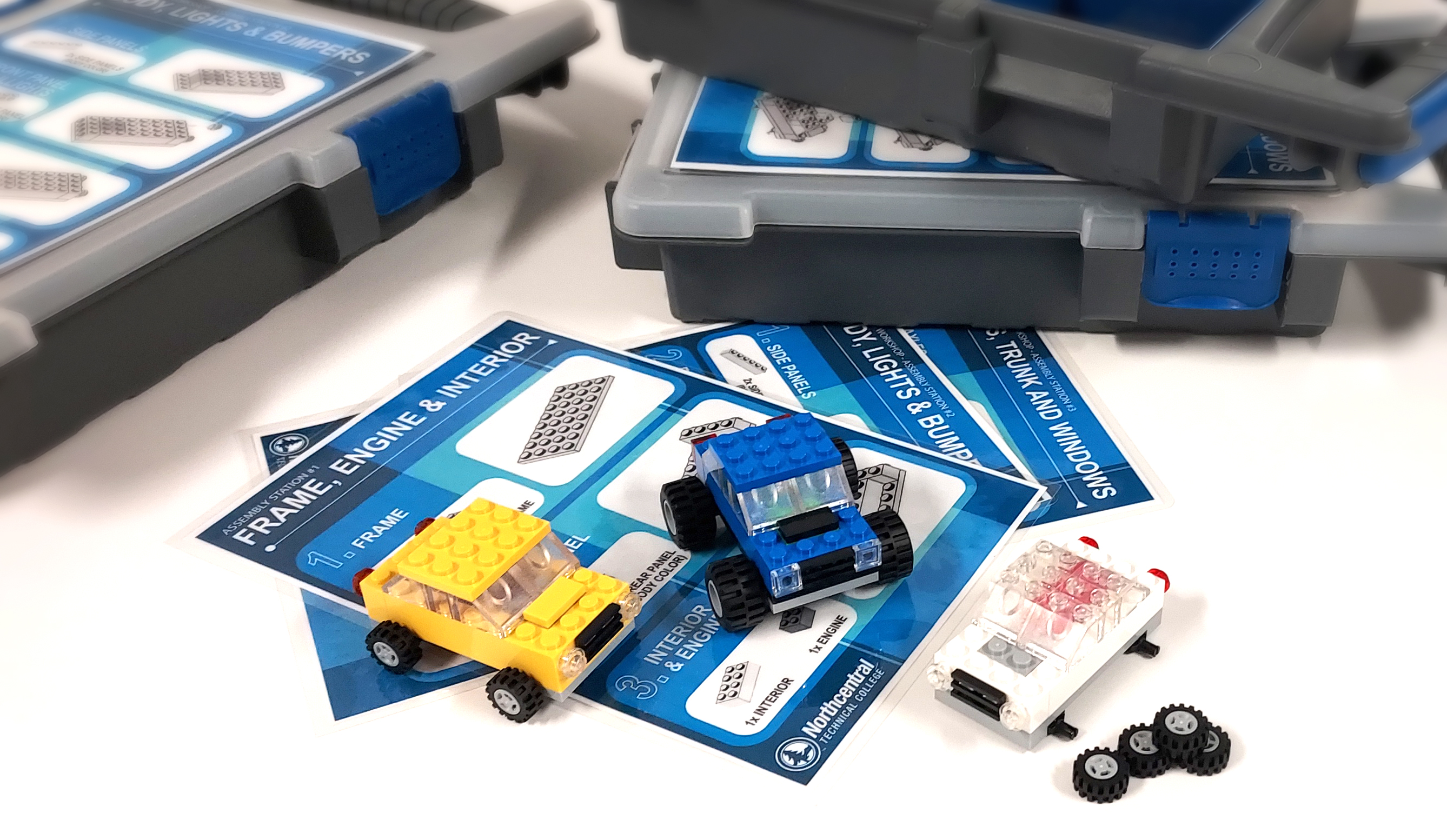 Assembled LEGO models sitting on a table on top of assembly sheets.