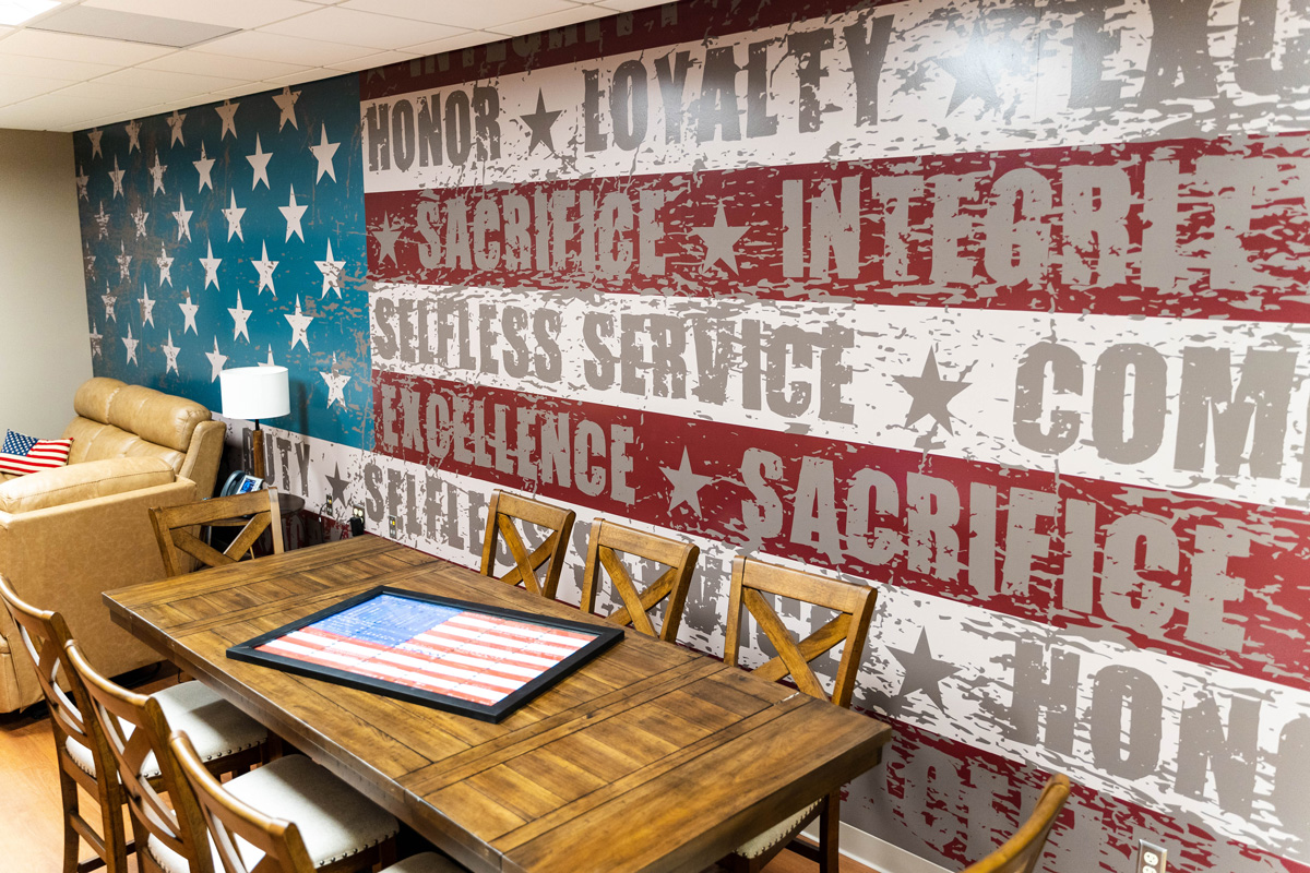 Internal view of the Veterans Day Room with a mural of the American flag painted on the wall in the background.