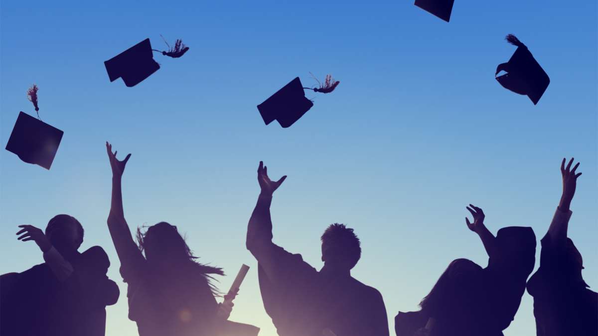 Students throw their graduating hats into the air