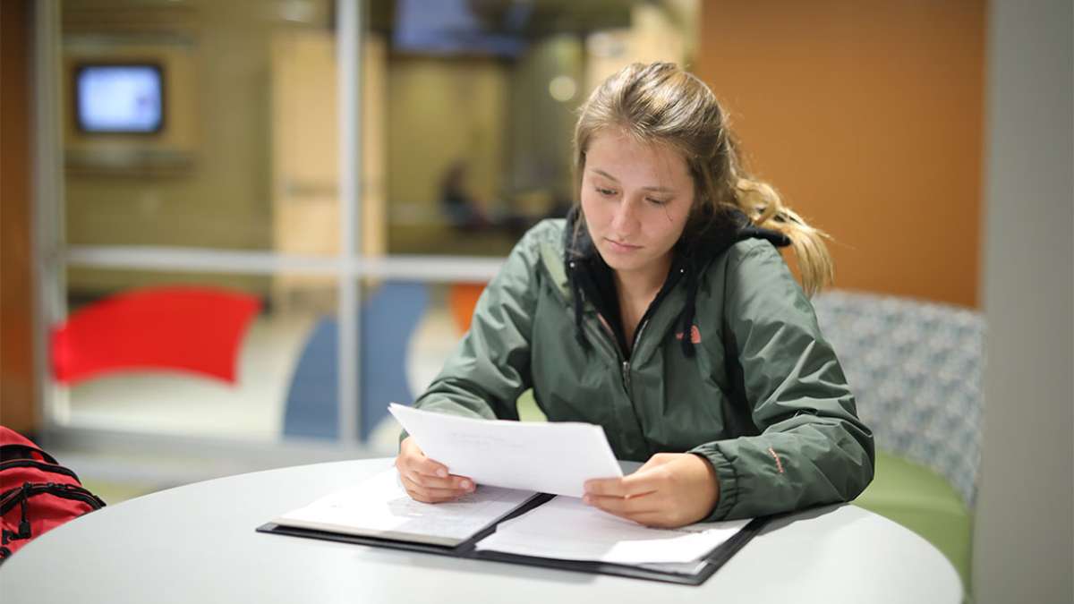 A student is sitting at a table doing homework
