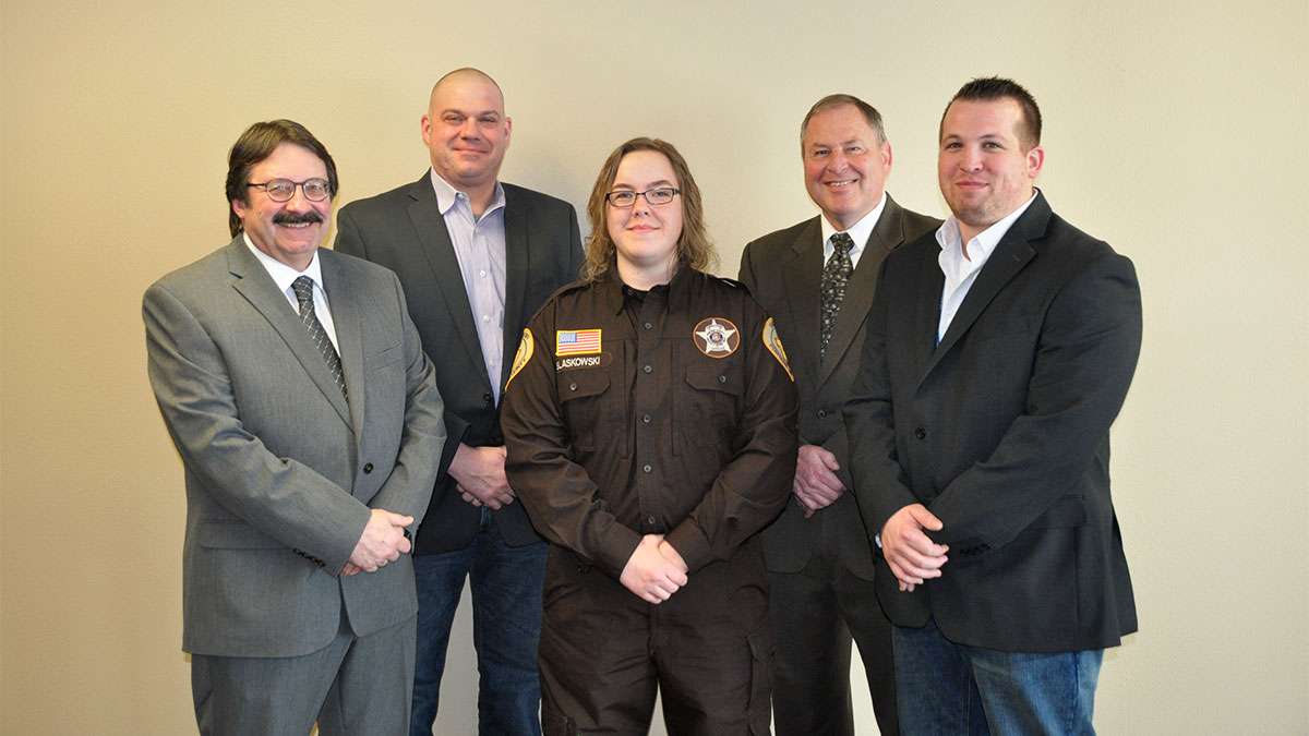 Graduate of Jail Academy Kaila Blaskowski stands between her instructors