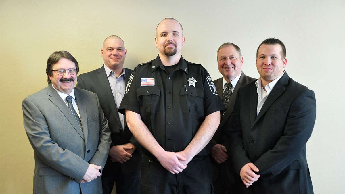 Jail Academy Graduate Marien stands between his instructors