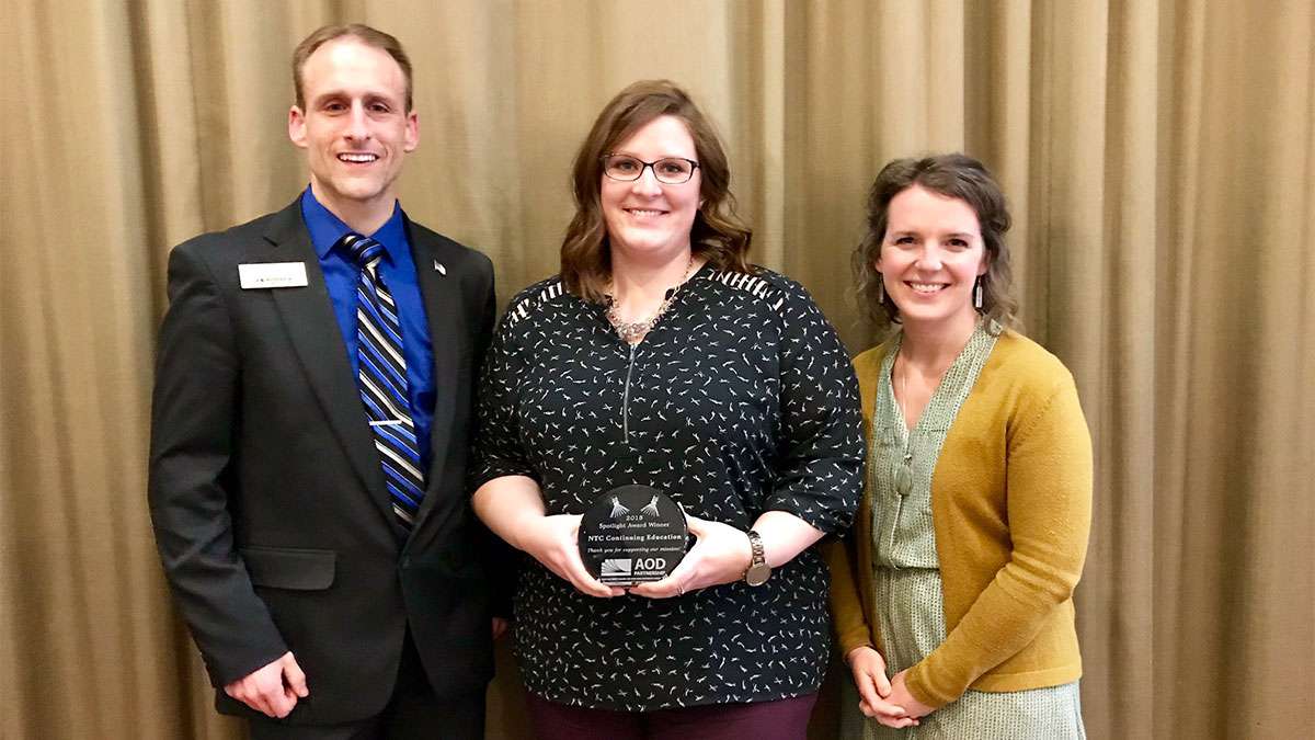 Brad Gast, Leslie Williams, Rachel Alwin stand together to accept an award