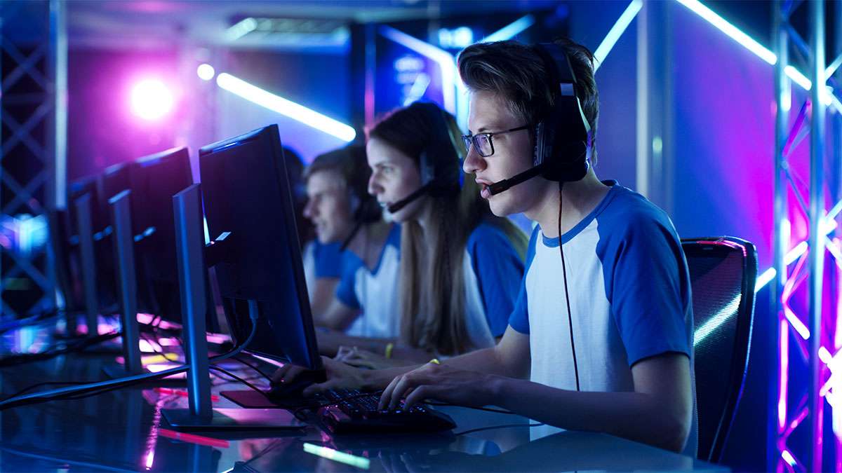 Four students competing on esports gaming machines