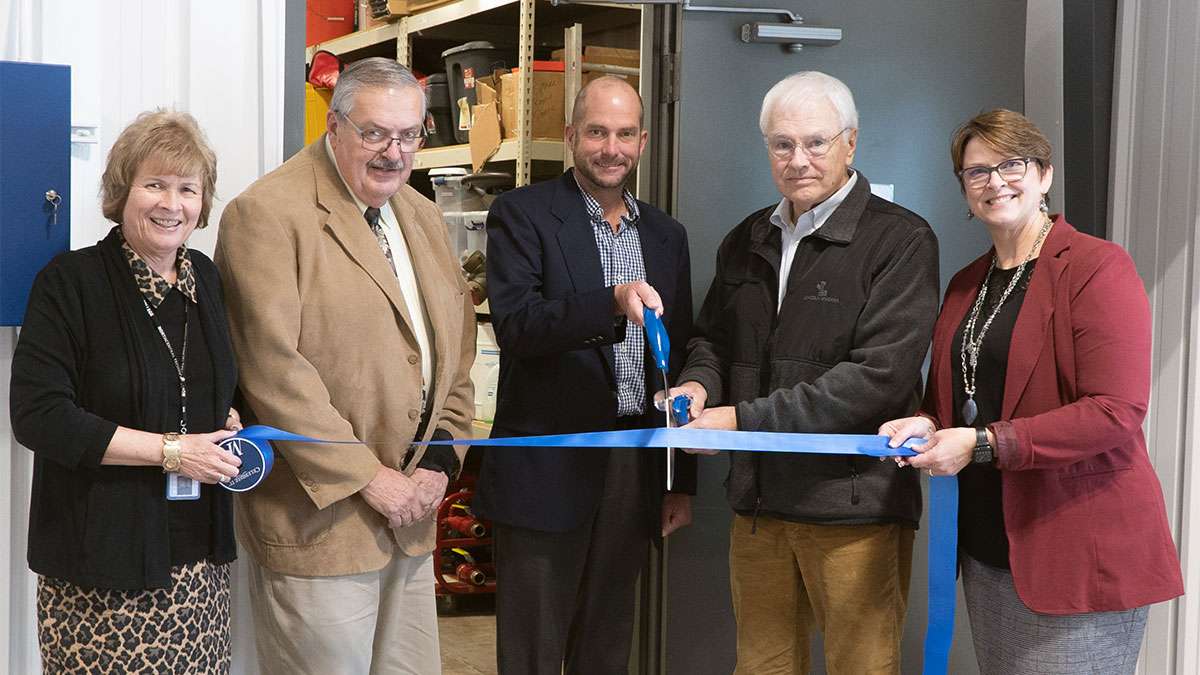Dr. Weyers stands with four people cutting a grand opening ribbon