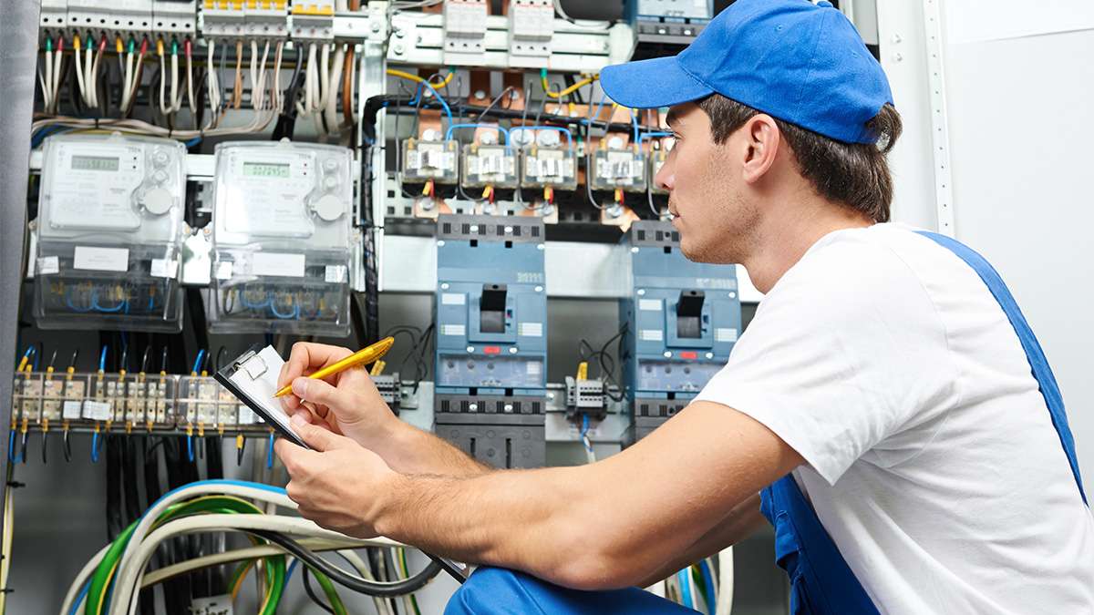 Electrical Engineering student viewing electric circuits with a pencil and clipboard in hand