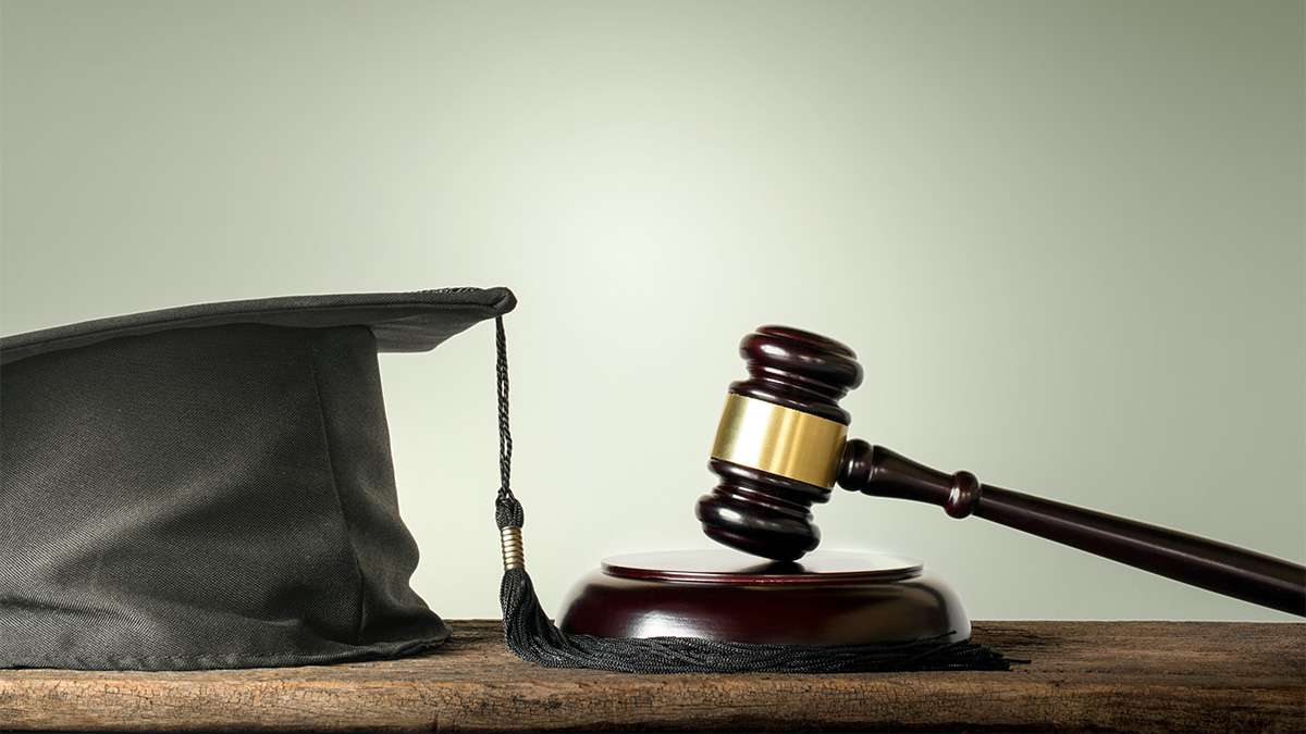 A graduation hat next to a gavel