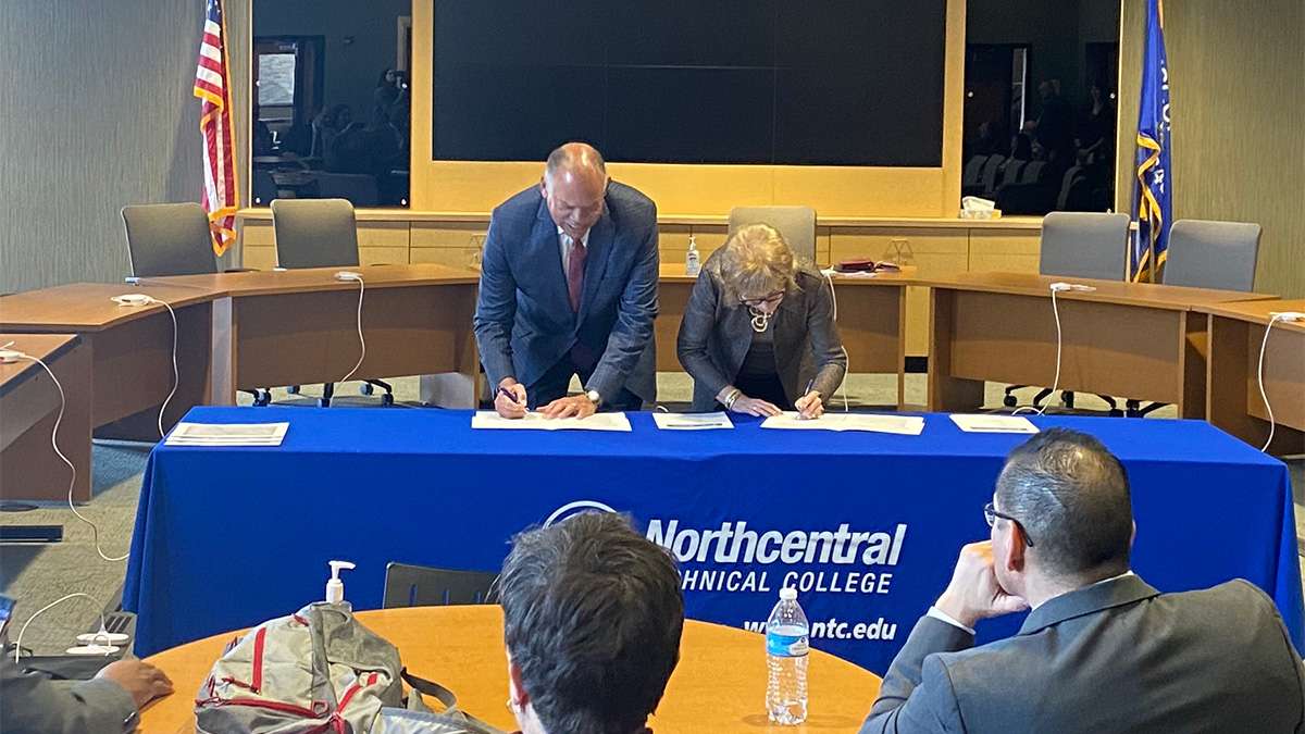 Dr. Lori Weyers stands with Dr. Jack E. Daniels, III signing the official partnership agreement for Liberal Art Transfer Associate Degree at NTC