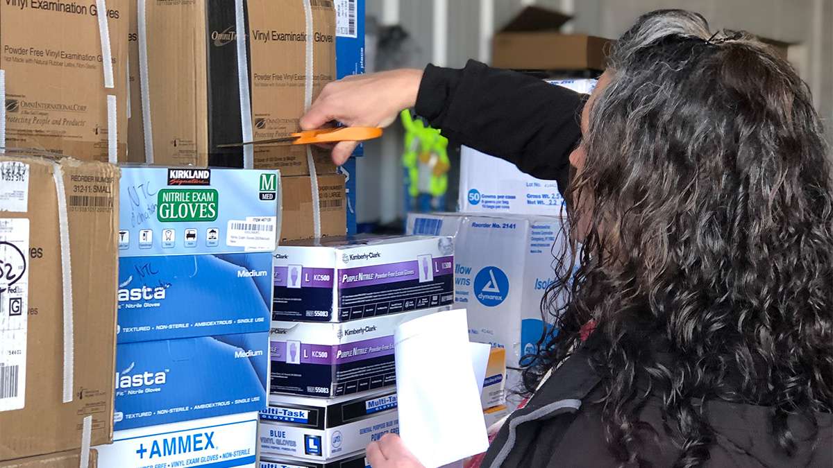 An NTC employee is sorting through various medical supplies