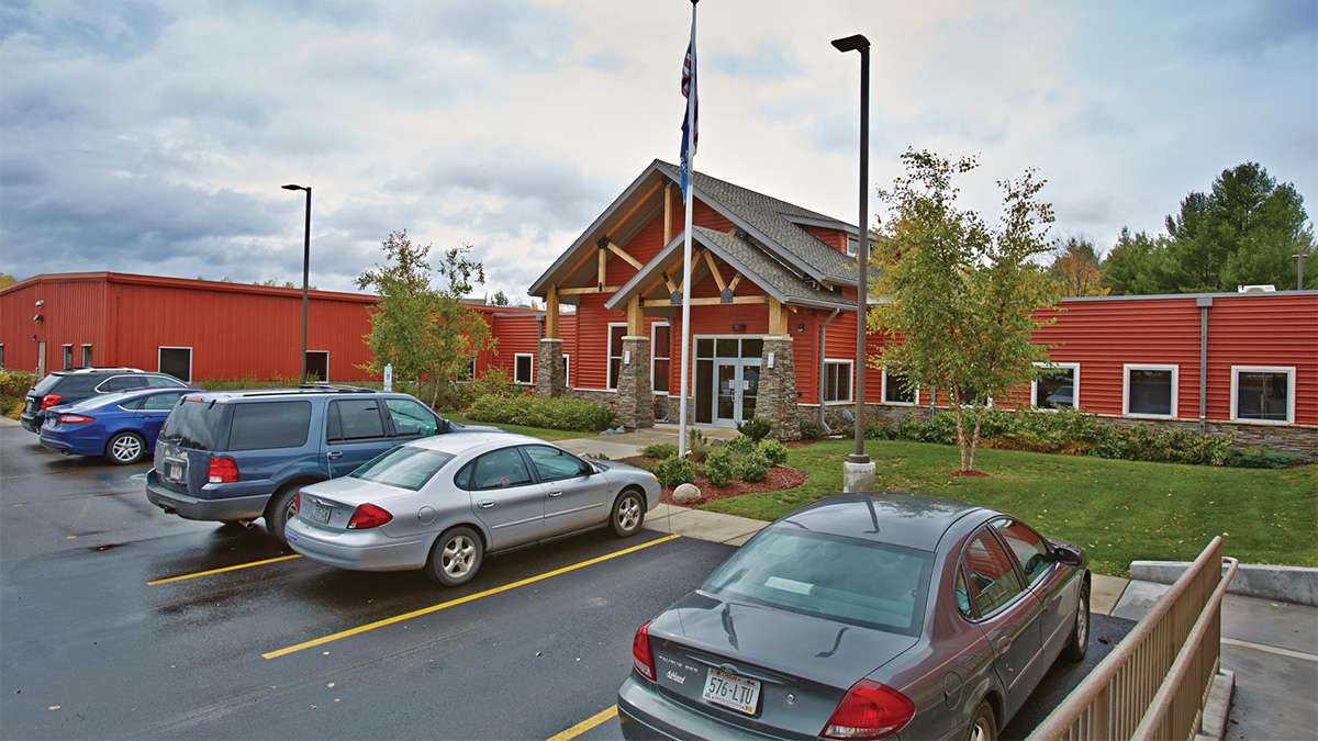 An external view of the NTC Phillips Campus with several cars in front parked in front of the entrance.