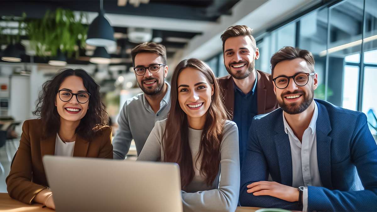 A team of professionals, both men and women in a modern office, showcasing their enthusiasm and camaraderie.