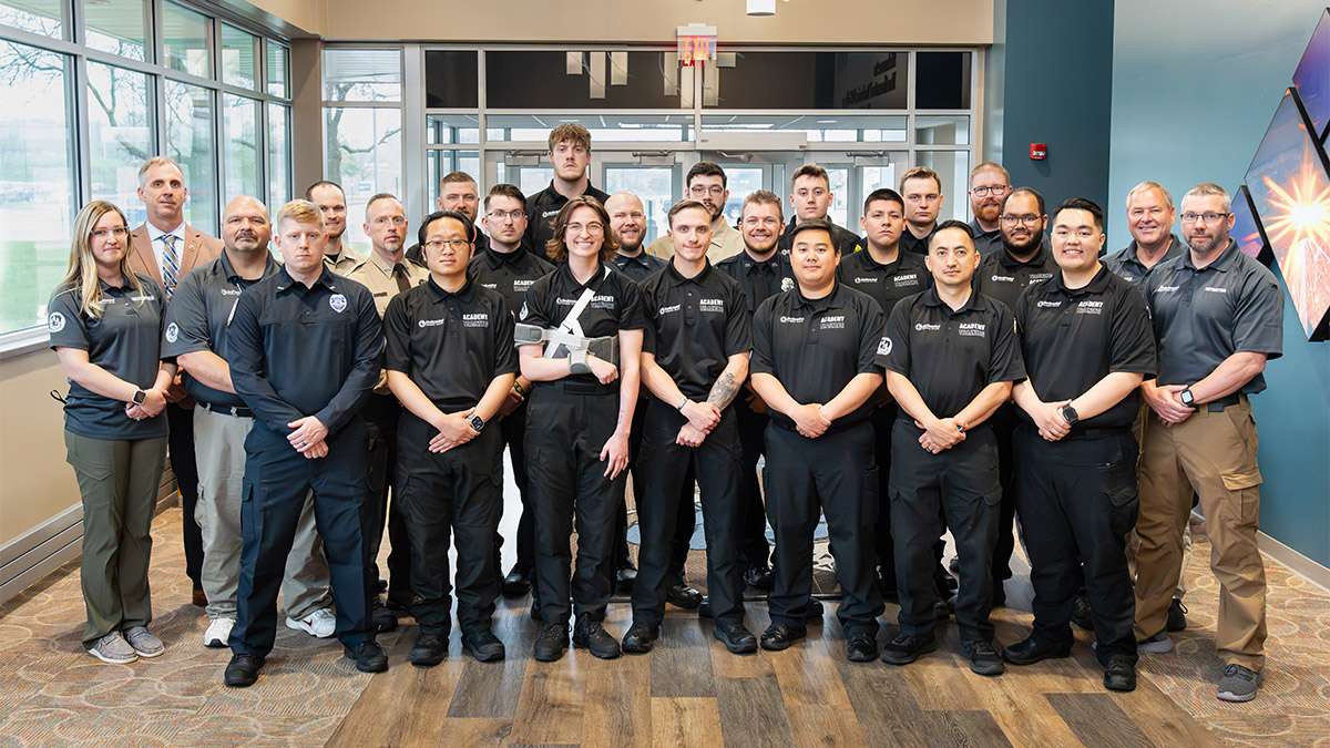 The Criminal Justice Graduates of 2024 stand together with their instructors at the Northcentral Technical College entrance.