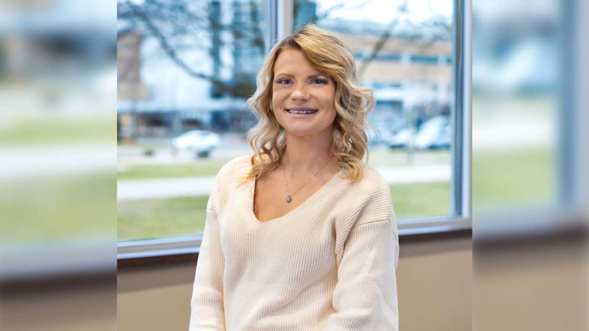 Kayla smiling while standing in front of a window inside the Wausau Campus