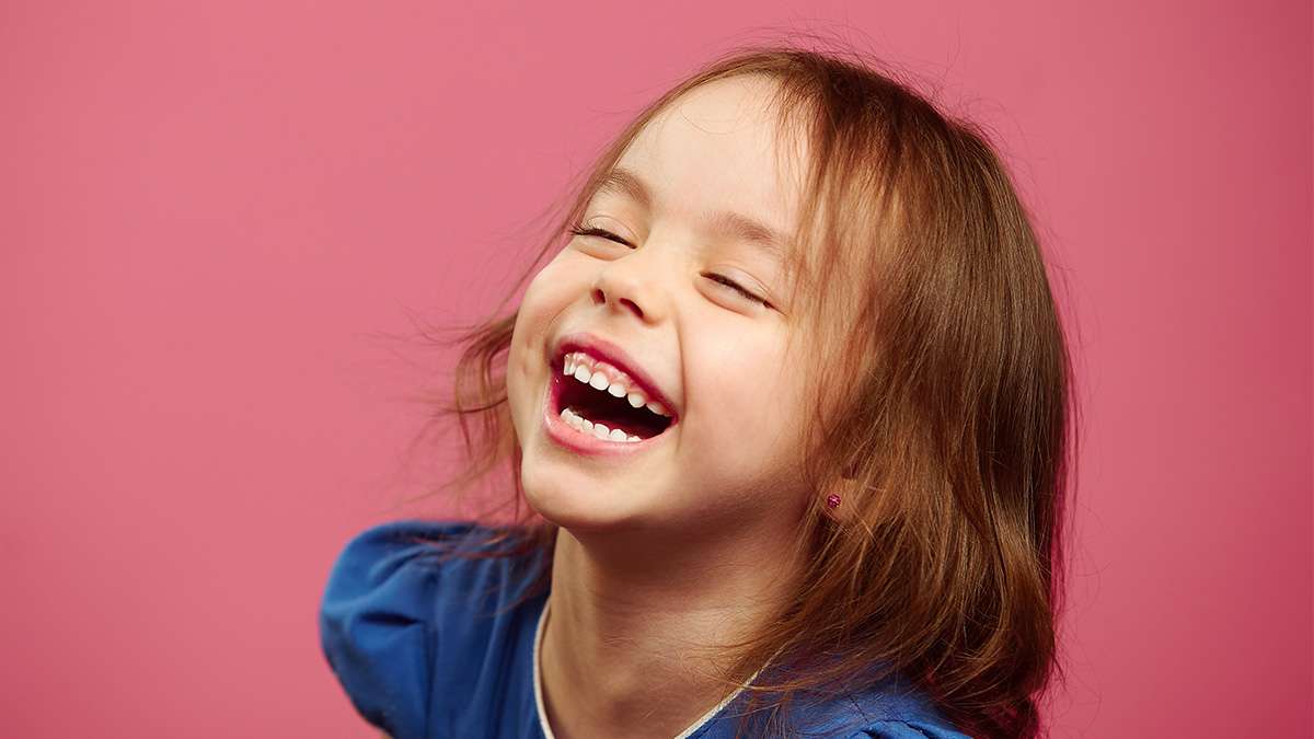 Smiling child with healthy teeth, representing dental sealant benefits.