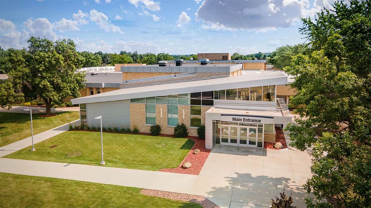 Aerial view of the Northcentral Technical College front entrance under a blue sky with scattered clouds.