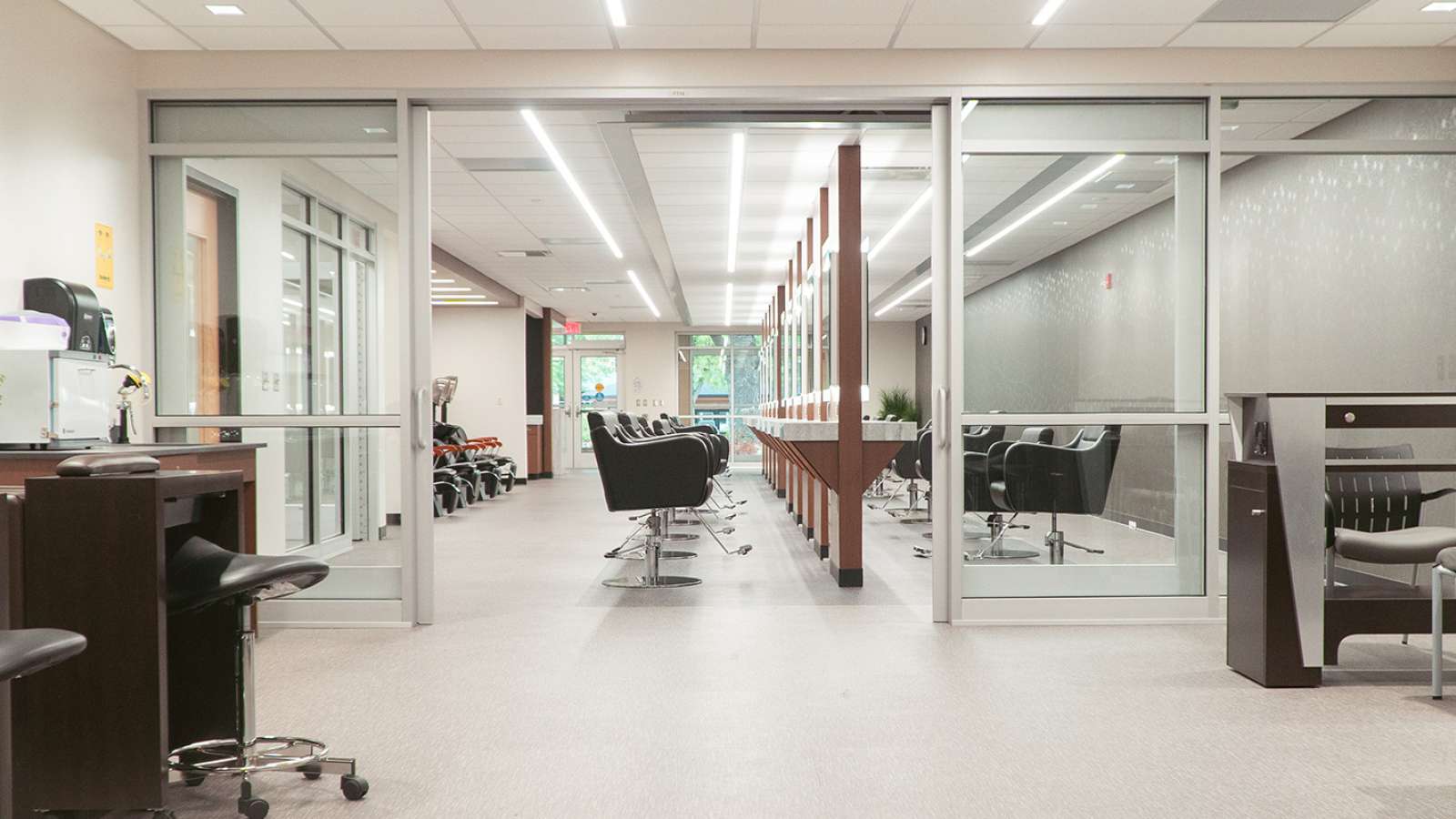 A wide interior view of pedicure chairs and hair cutting booths in Studio Max Salon and Spa