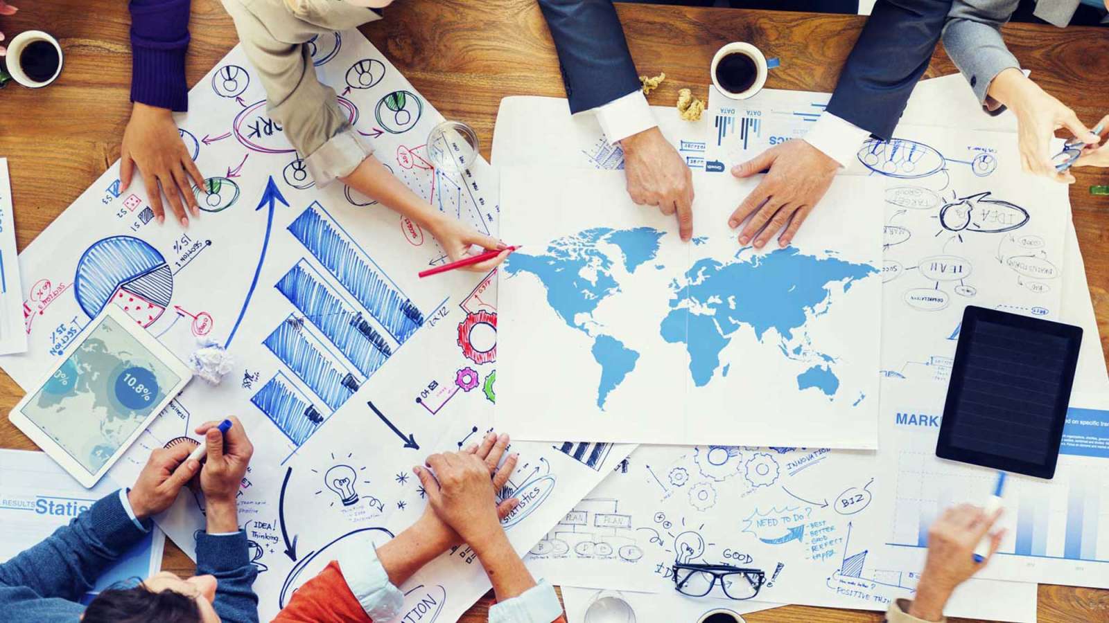 A group of marketing experts strategize as they sit around a table full of creative materials.