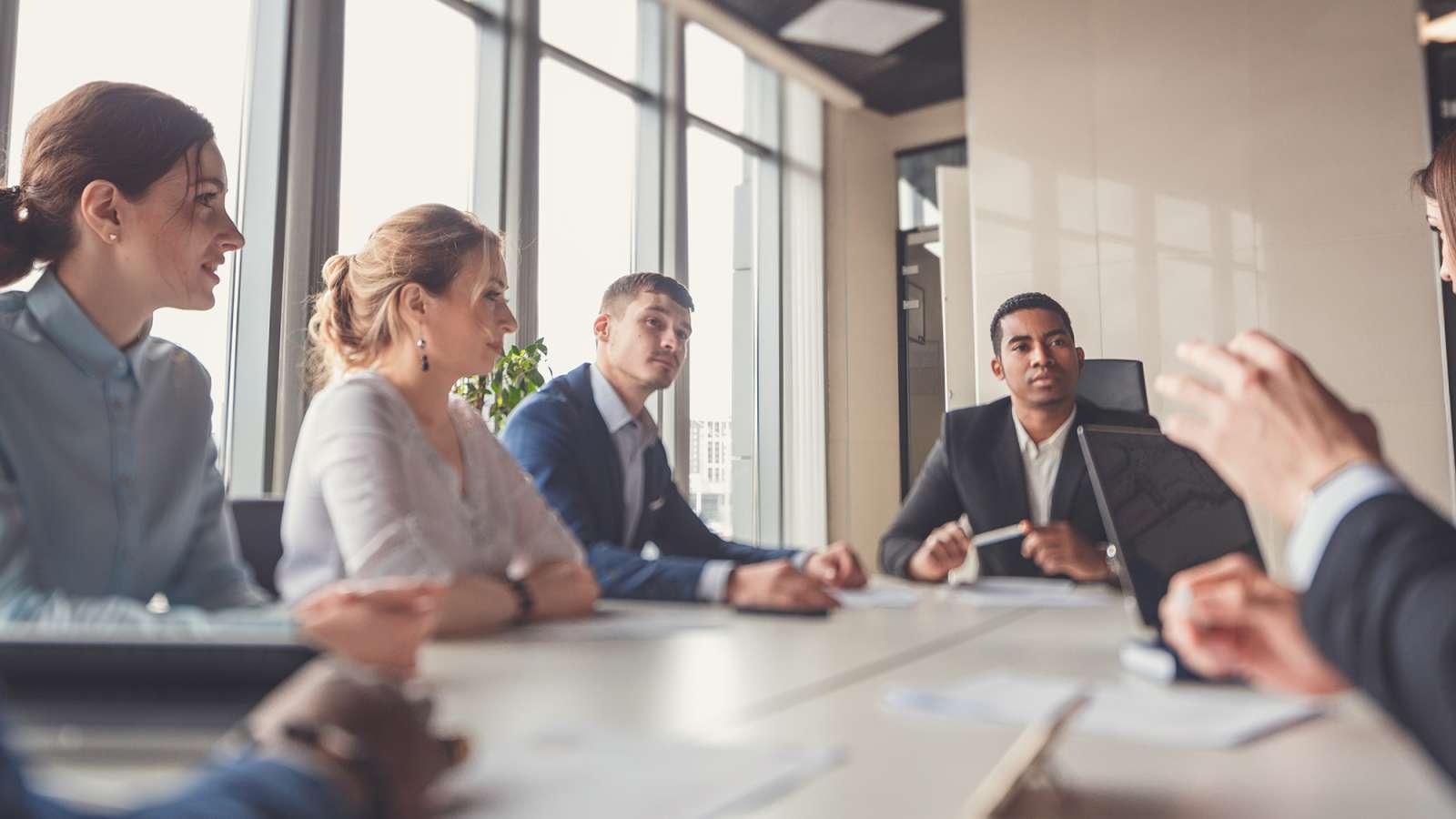 Group of business people with businessman leader sitting at the head of the table.