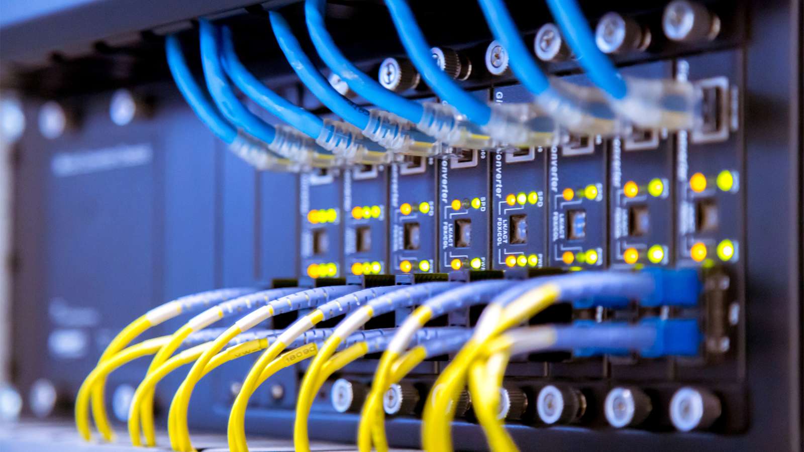 A close up view of network switches and ethernet cables inside of a server room.