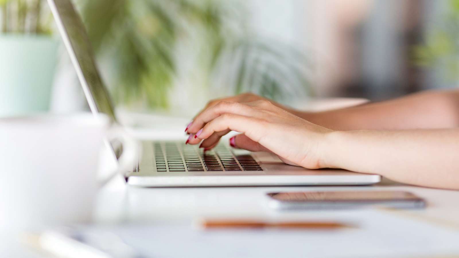 Close up of hands typing on a laptop.