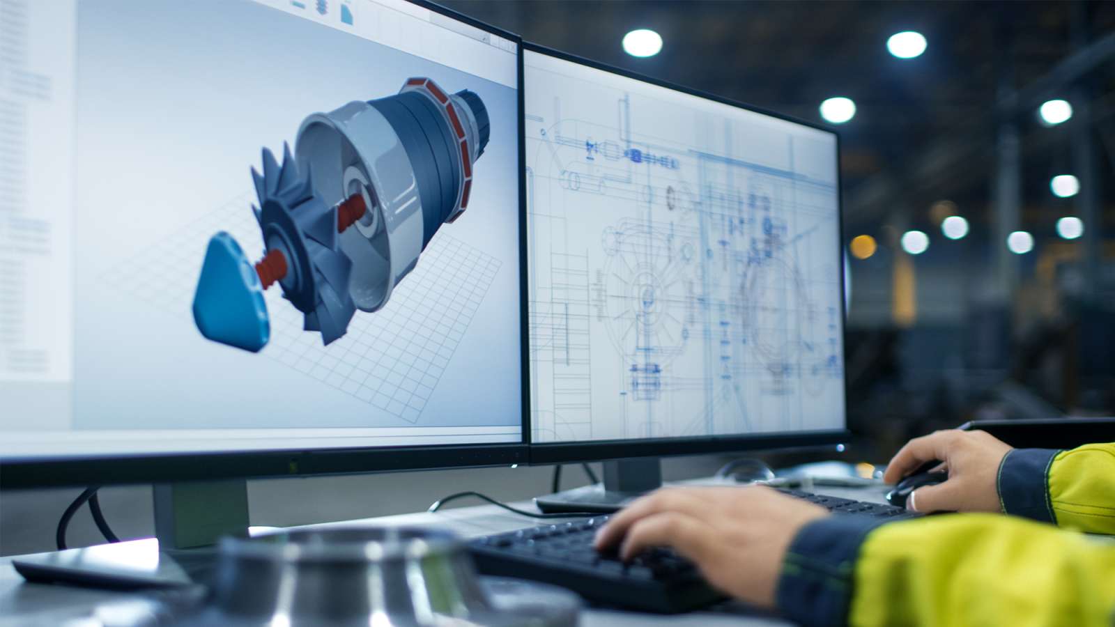 Close-up footage of Industrial Engineer's hands working on two monitors designing Turbine/ Engine in 3D, using CAD.