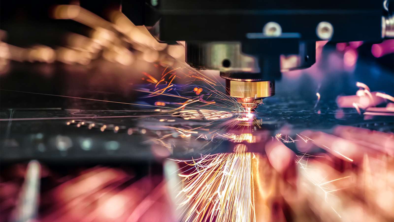 A Robotic CNC Laser cutter is cutting metal inside of an industrial factory.