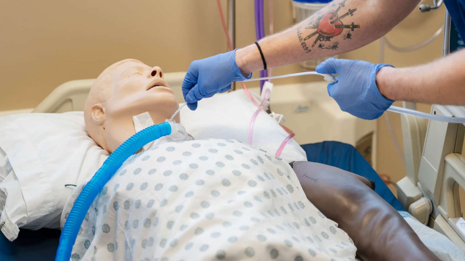 A close-up view of a mannequin as a student holds tubing for oxygenation.