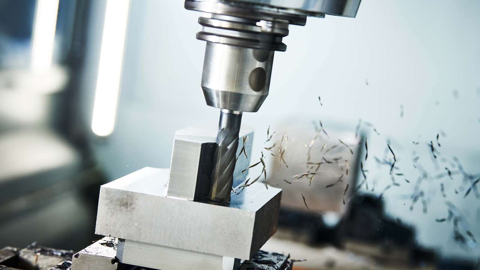 A CNC Milling machine is cutting a rectangular shape out of a piece of metal.