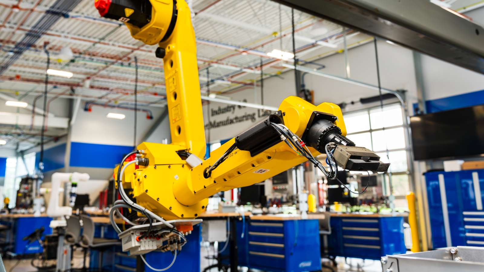 A robotic arm suspended from a beam within the Industry 4.0 Smart Manufacturing Lab