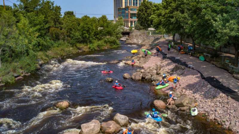 An aerial photo of downtown Wausau kayakers, shot by a camera mounted to a drone.