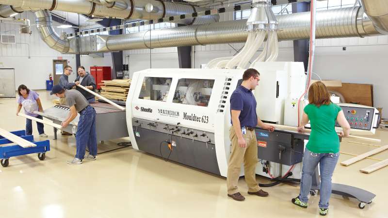 Two students are operating a Moulder