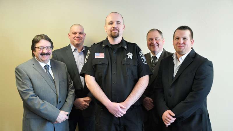 Jail Academy Graduate Marien stands between his instructors