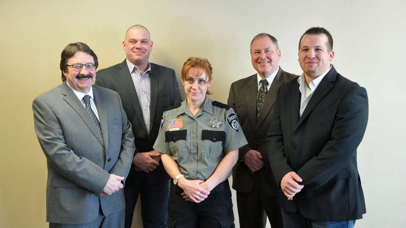 Jail Academy Graduate Melissa McLain stands between her instructors