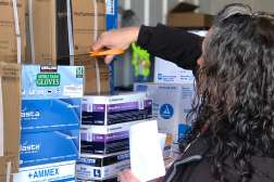 An NTC employee is sorting through various medical supplies