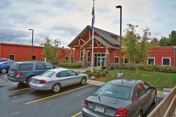 An external view of the NTC Phillips Campus with several cars in front parked in front of the entrance.