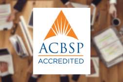 ACBSP Accredited branding logo overlayed on top of a background focusing on business persons sitting at an office table.