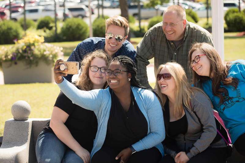 A group of students taking a selfie outside