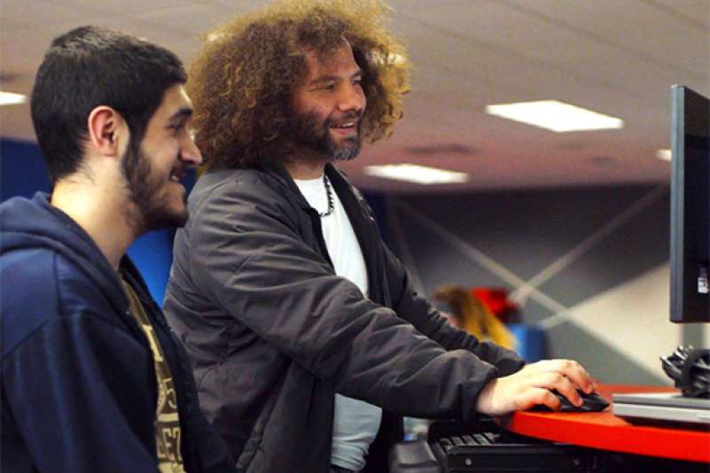 A student is tutoring another student in the Information Technology Entrepreneurial Center (iTEC)