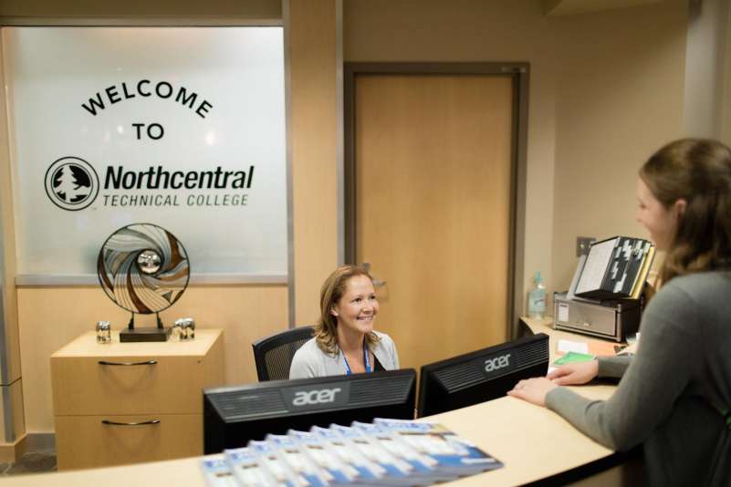 Student talking to a staff member at the front desk of the NTC Wausau Campus.