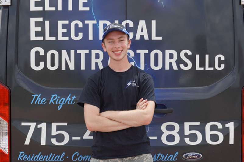 Brenden Rohland stands in a room full of tools, explaining the benefits of a youth apprenticeship.