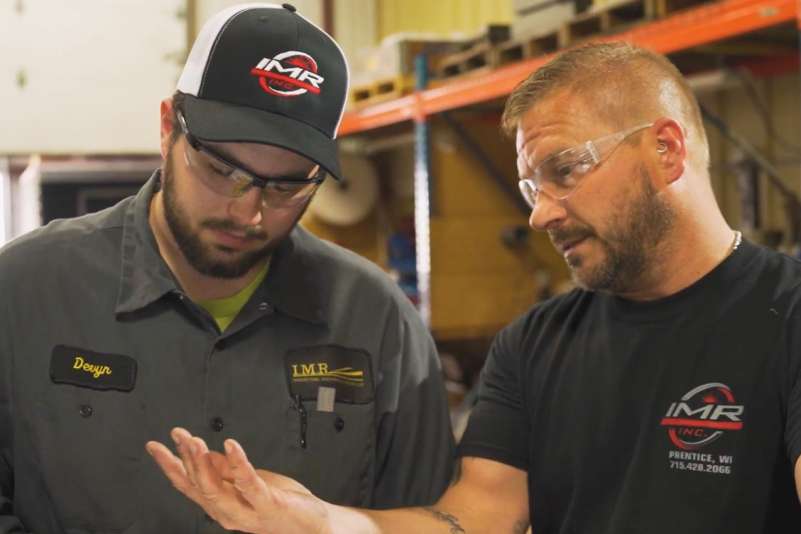 An apprentice learning from an experienced professional in a job setting.