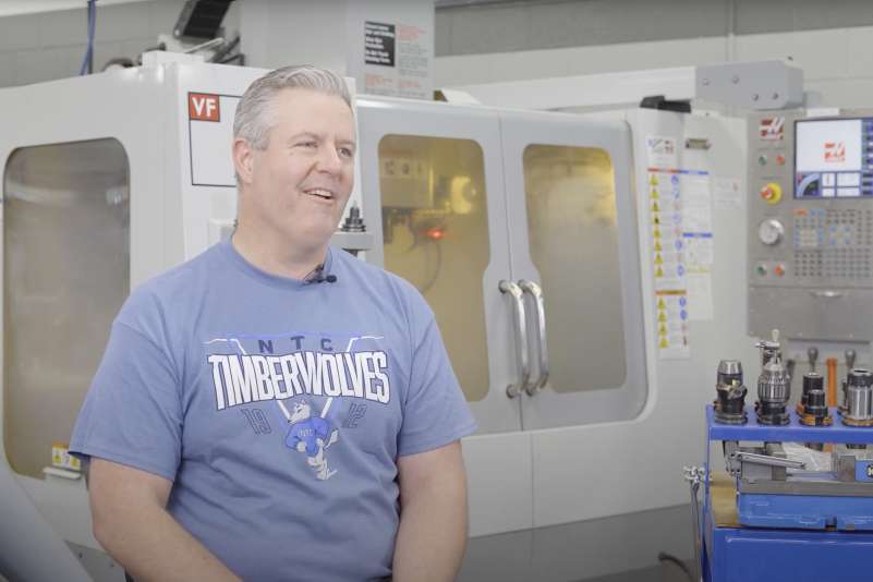 Apprentice John Rupple sitting in front of Tool and Die equipment