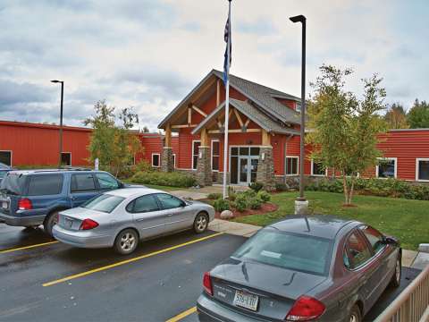 An external view of the NTC Phillips Campus with several cars in front parked in front of the entrance.