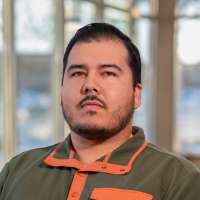 Rainer Shooter poses while standing near the front entrance, inside the Wausau Campus.