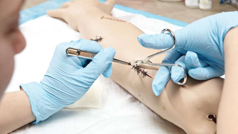 Student working on a suture practice arm