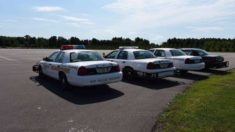 Four NTC police training vehicles parked in the practice area