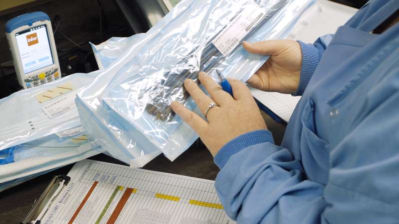 A woman is analyzing some materials wrapped in a plastic bag.